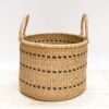 a woven laundry basket with handles