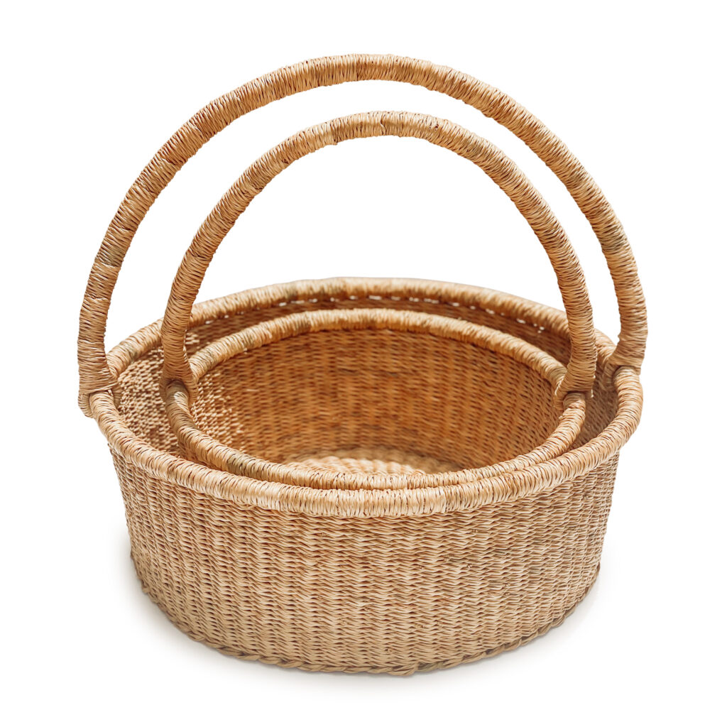 a stack of woven picnic baskets with handles on a white background