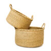 a stack of woven plant baskets on a white background